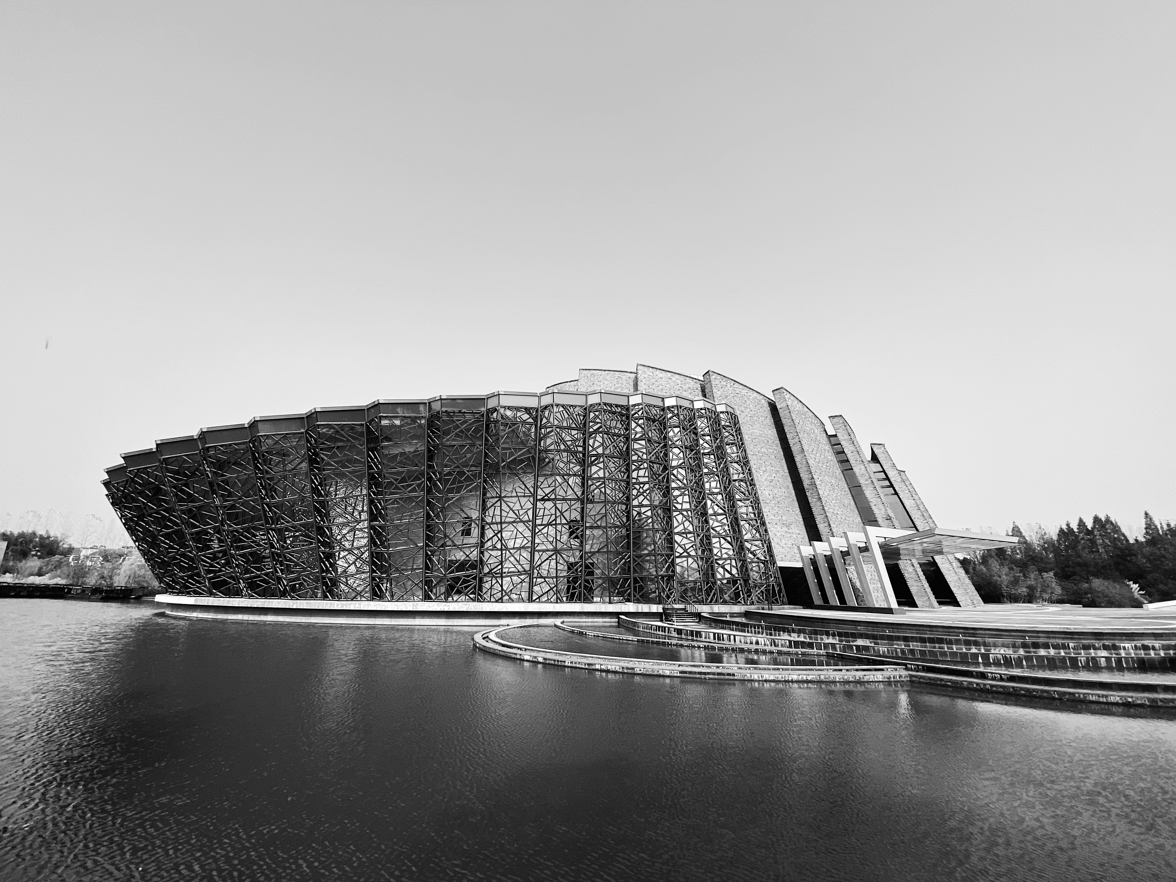 grayscale photo of building near body of water